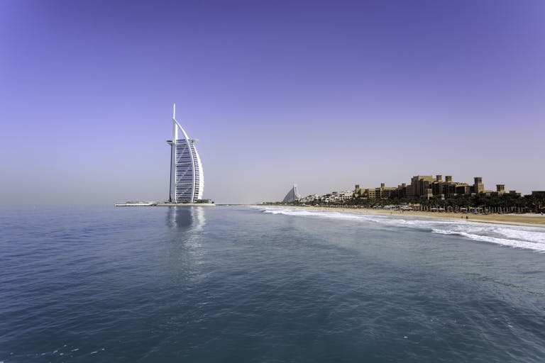 Iconic Burj Al Arab overlooking the pristine Dubai beach, perfect for travel and leisure.